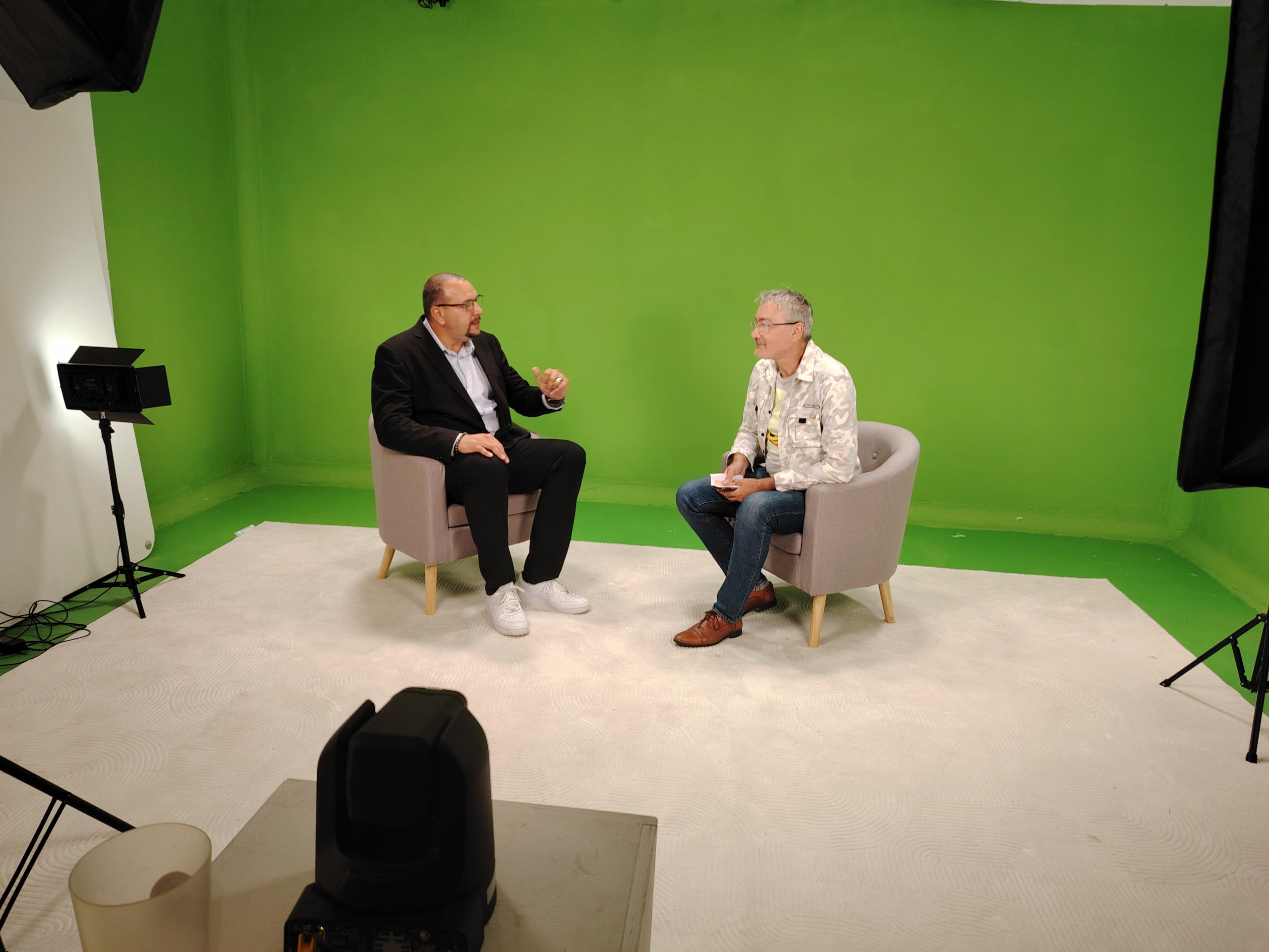 Podcast côté studio Photo du tournage d'une interview avec fond vert